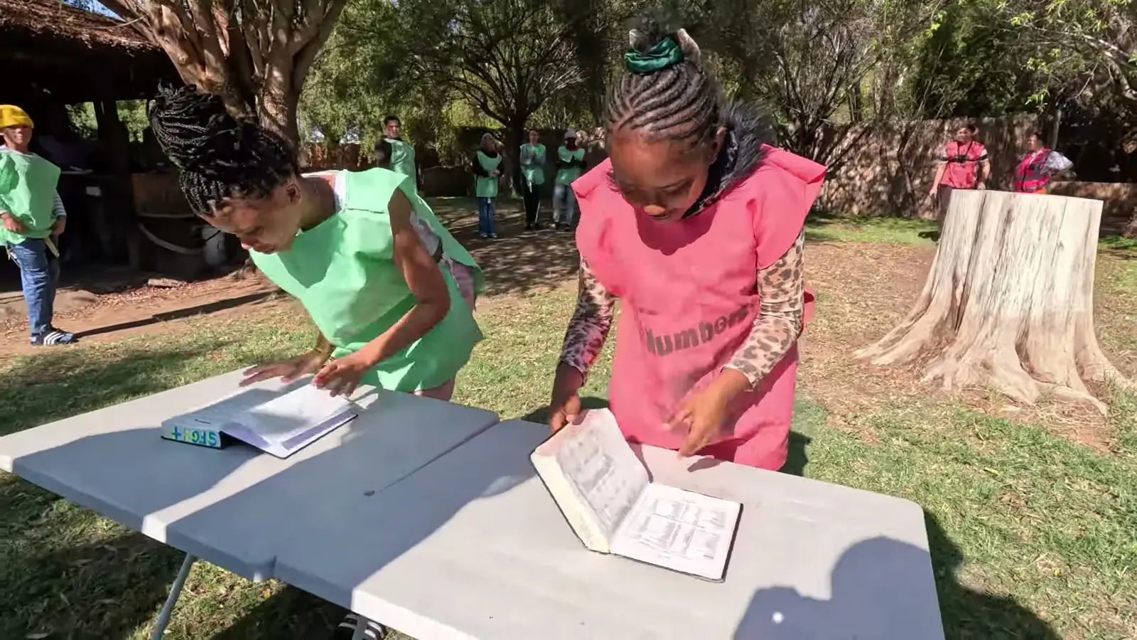 Two campers racing through a Bible study at a table