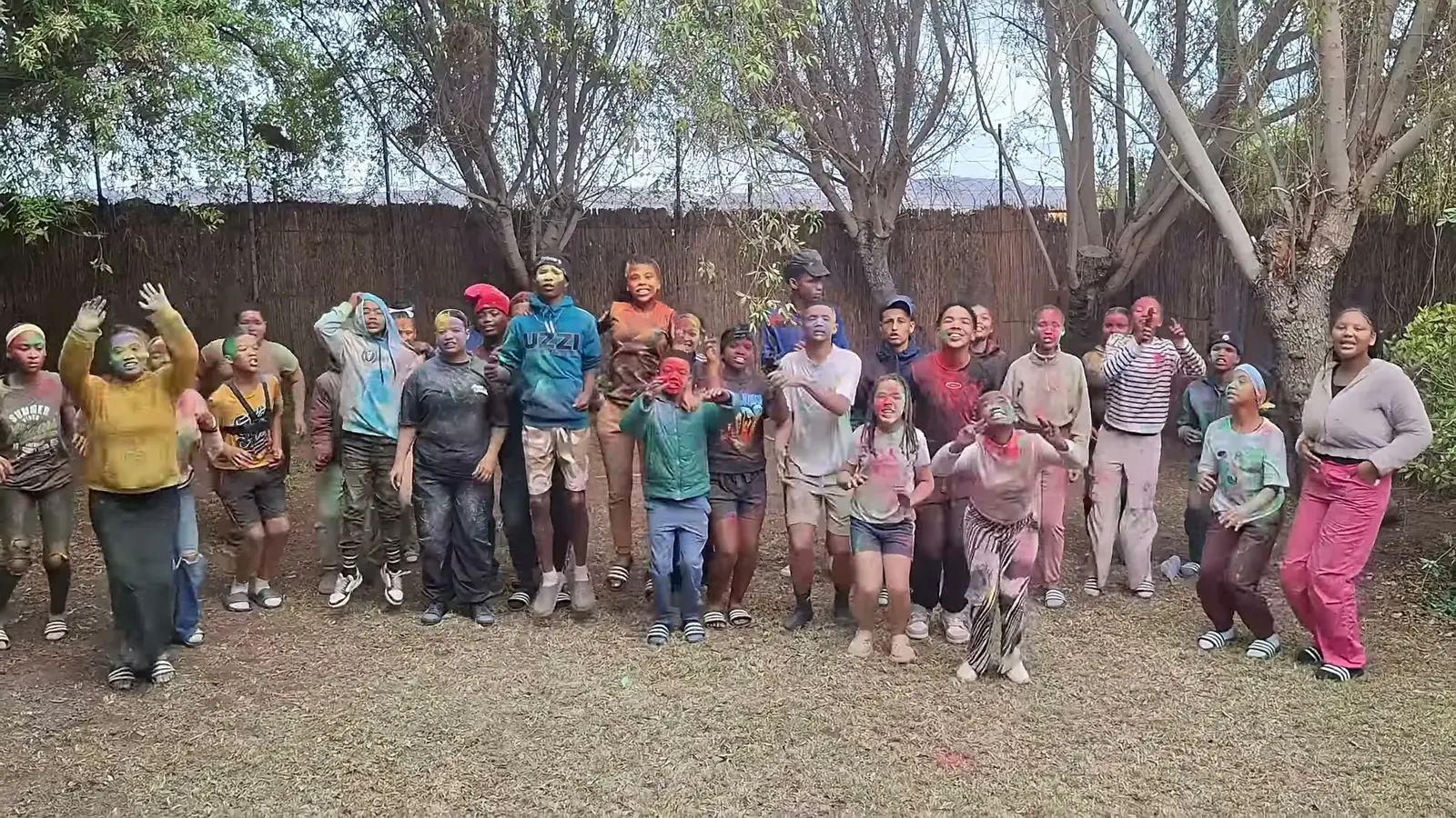 Campers covered in coloured powder cheer after the colour fight