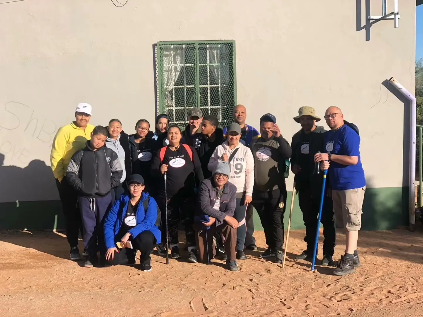 Hiking team with walking sticks gathered for a group photo